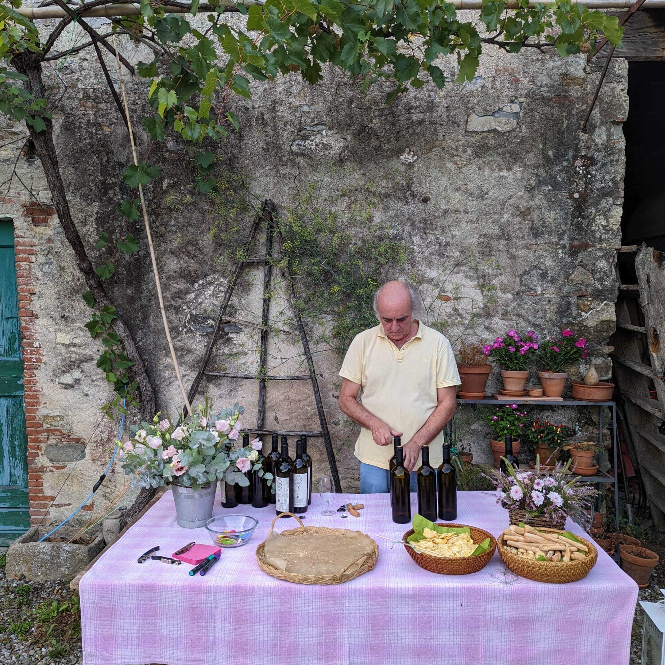 The owner of the vineyard opens and prepares the wine bottles for the tasting