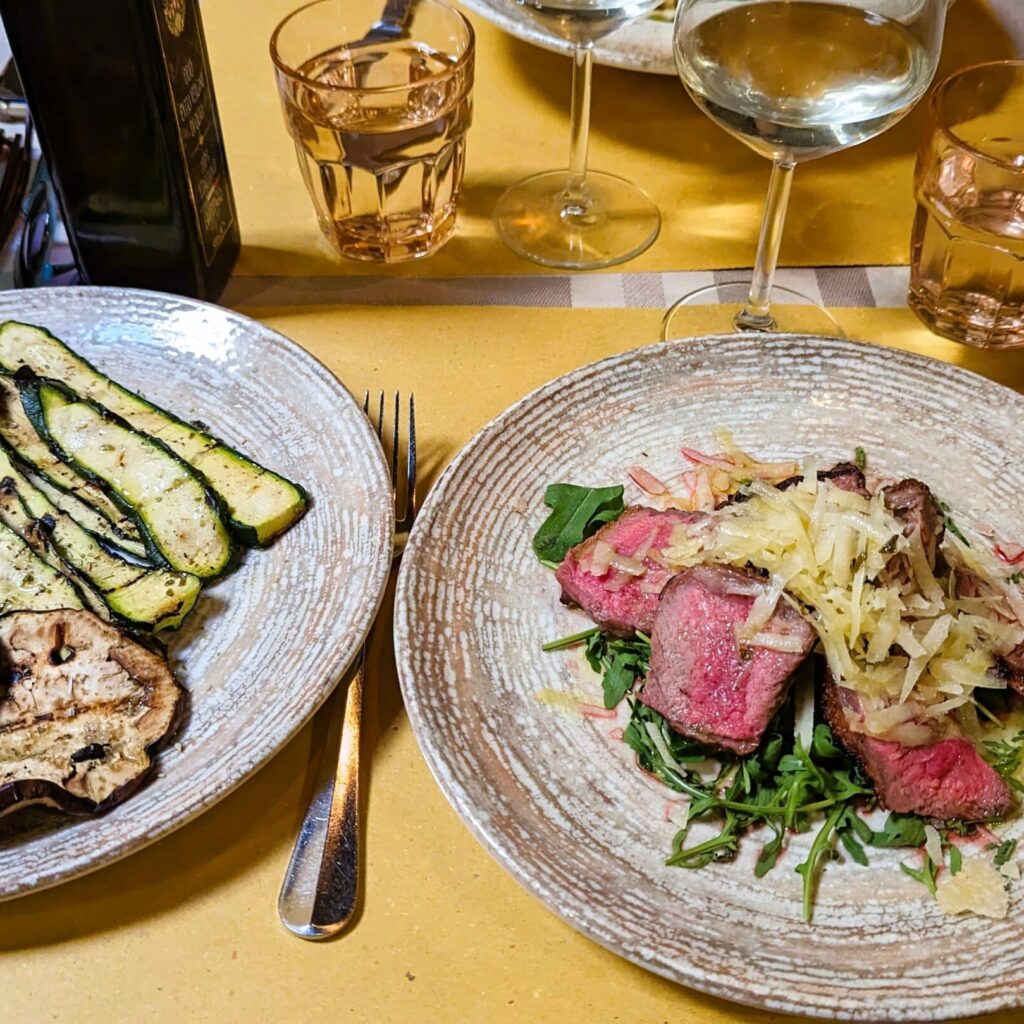 Famous beef tagliata from Florence with rucola, parmesan and roasted vegetables